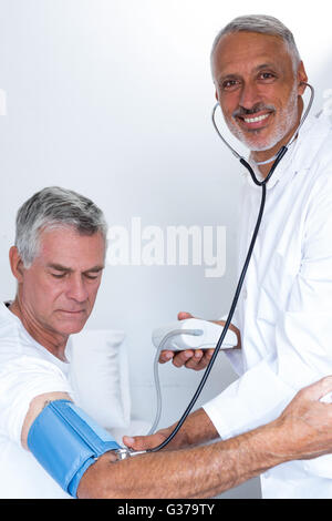Maschio il controllo medico mans senior della pressione del sangue Foto Stock