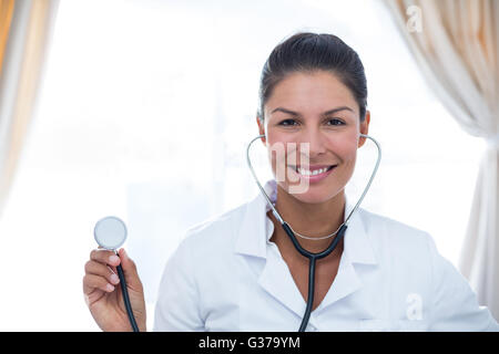 Ritratto di medico donna che mostra uno stetoscopio Foto Stock