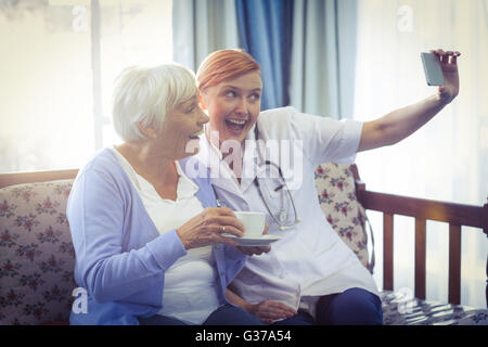 Sorridendo Il medico e il paziente tenendo un selfie Foto Stock