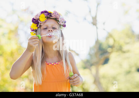 Ragazza giovane soffiare bolle attraverso il bubble wand Foto Stock