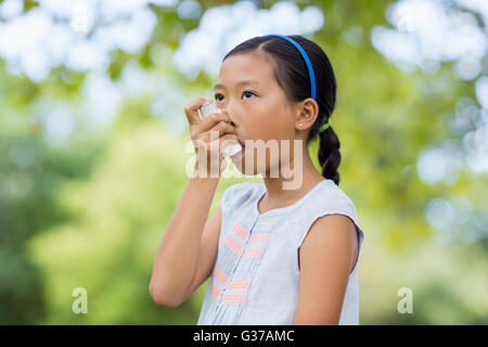 Ragazza con un inalatore per asmatici Foto Stock