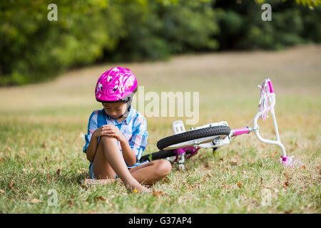 Ragazza giovane ferite dopo la caduta dalla bicicletta Foto Stock