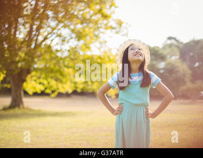 Ragazza sorridente in piedi con la mano sul hip in posizione di parcheggio Foto Stock