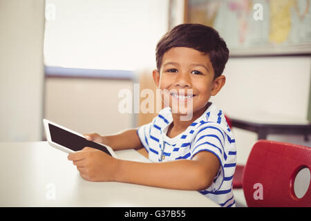 Ritratto di scolaro utilizzando digitale compressa in aula Foto Stock