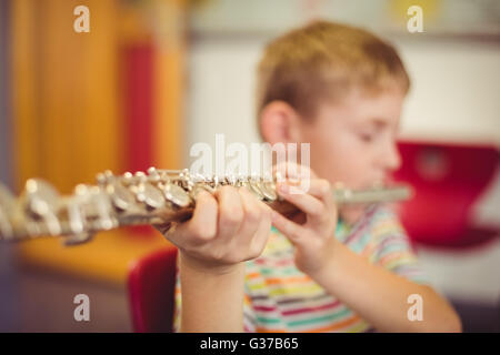 Scolaro riproduzione di flauto in aula Foto Stock