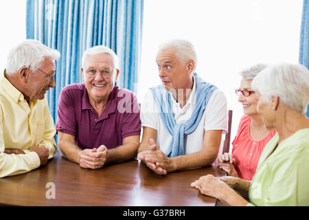 Gli anziani parlando a tavola Foto Stock