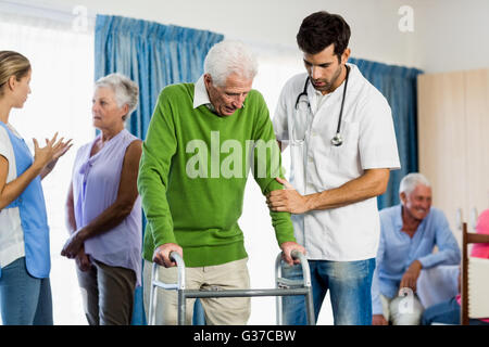 L'infermiera aiutando senior con ausili per la deambulazione Foto Stock