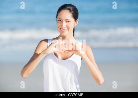 Donna che fa a forma di cuore Foto Stock