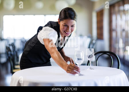 Sorridente cameriera impostazione della tabella Foto Stock