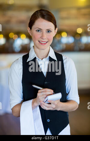 Ritratto di sorridente cameriera facendo ordine Foto Stock