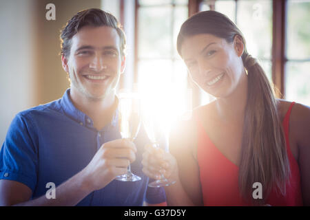 Ritratto di giovane coppia di tostatura flauti di champagne mentre a pranzo Foto Stock