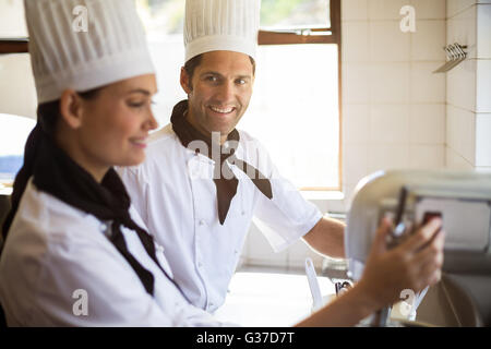 Ritratto di chef miscelando la pastella nella miscelazione del frullatore Foto Stock