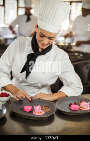 Donna sorridente finitura chef piatti da dessert Foto Stock