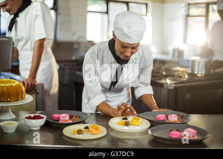 Donna sorridente finitura chef piatti da dessert Foto Stock