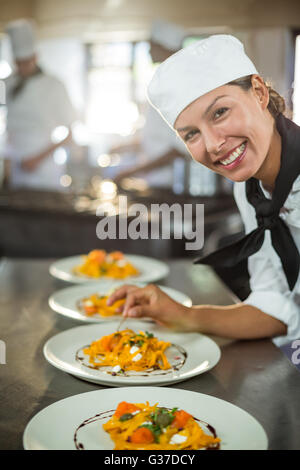 Ritratto di donna chef piastra di farcitura di prodotti alimentari Foto Stock