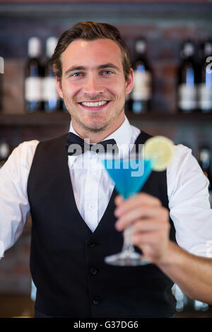 Ritratto del barista serve una blue martini Foto Stock