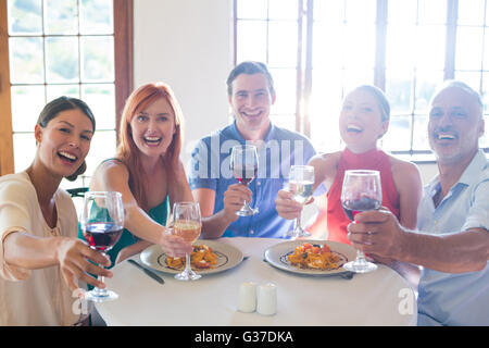 Mostra gli amici di vetro di vino mentre avendo pranzo Foto Stock