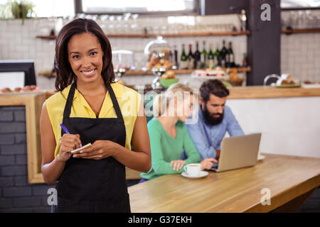 Cameriera facendo ordine su un notebook Foto Stock