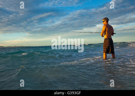 Brad Osborn pesca di Papio al sorgere del sole sulla spiaggia a Namotu Island, Isole Figi Foto Stock