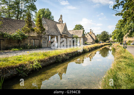 LOWER Slaughter, Regno Unito - 12 agosto 2015: Fiume nel villaggio un cielo blu al giorno. Macellazione inferiore è noto per le sue case di calcare Foto Stock