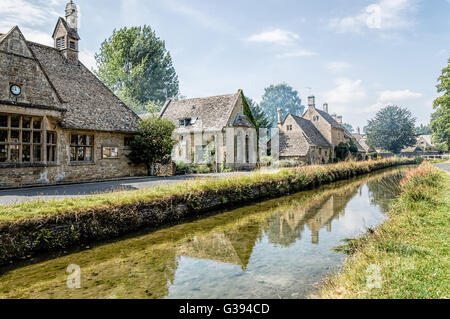 LOWER Slaughter, Regno Unito - 12 agosto 2015: Fiume nel villaggio un cielo blu al giorno. Macellazione inferiore è noto per le sue case di calcare Foto Stock