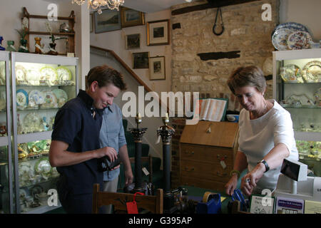 Cotswolds. Transazione in antichità al George a Burford High Street. Burford è nota per i suoi negozi di antiquariato. Foto Stock