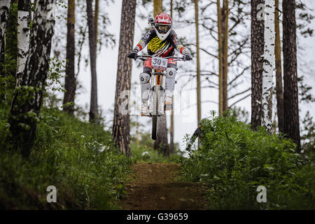 Atleta racer Bike jump con una montagna nella foresta sul casco videocamera durante la coppa Ryder "' in discesa Foto Stock