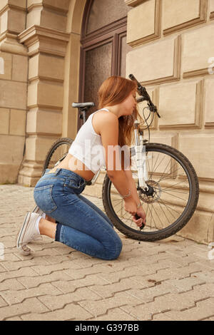 Ragazza pompe fino pneumatici di biciclette Foto Stock