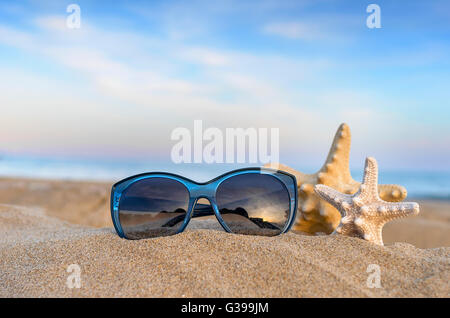 Marine ancora in vita. Il flip flop, occhiali da sole e stelle marine il mare e il cielo dello sfondo. Foto Stock