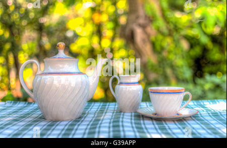 La prima colazione nel giardino con un set per il tè sul tavolo Foto Stock