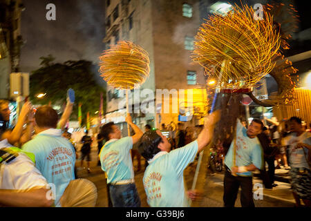 Un carrier di paranchi aloft la tremante e fiery incenso laden testa dell'ormai famoso Fire Dragon Dance in Tai Hang, Hong Kong. Foto Stock