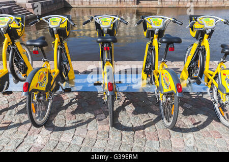 Helsinki, Finlandia - 21 Maggio 2016: Giallo biciclette da città per affitto di stand in una fila, vista posteriore Foto Stock