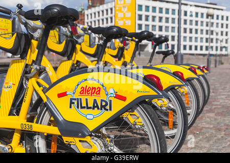 Helsinki, Finlandia - 21 Maggio 2016: Giallo biciclette da città per affitto di stand in una fila nella città Foto Stock