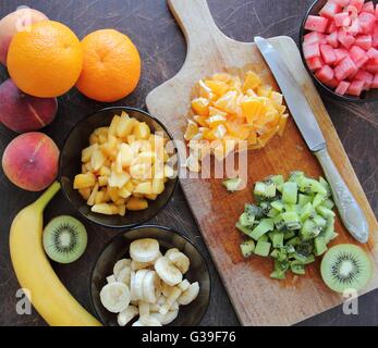 Frutta fresca tagliata sulla scrivania in legno Foto Stock