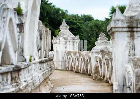 Hsinbyume Pagoda struttura a terrazze Mingun Myanmar // MINGUN, Myanmar — intricati motivi a onda concentrica adornano la struttura a terrazze bianche della Pagoda di Hsinbyume, nota anche come Pagoda di Myatheindan. La pagoda fu costruita nel 1816 dal principe Bagyidaw, in seguito re Bagyidaw, come memoriale della sua prima moglie, la principessa Hsinbyume, morta di parto. Il caratteristico design architettonico rappresenta le sette catene montuose intorno al Monte Meru secondo la cosmologia buddista. Situato a Mingun sulla riva occidentale del fiume Irrawaddy, la pagoda si trova a circa 11 chilometri a nord di Mandalay. Il bianco- Foto Stock