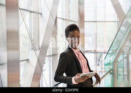 Ritratto aziendale fiducioso imprenditore con tavoletta digitale in un ufficio moderno lobby