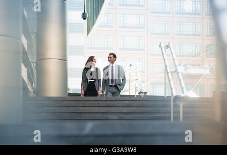 Corporate imprenditore e imprenditrice di discesa delle scale all'aperto Foto Stock