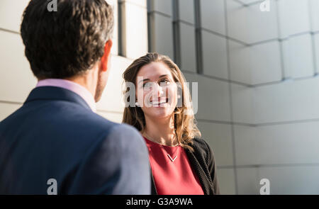 Corporate imprenditrice sorridente e parlando di imprenditore Foto Stock