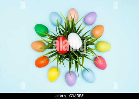 Colorate le uova di pasqua disposti in una disposizione circolare su sfondo pastello Foto Stock