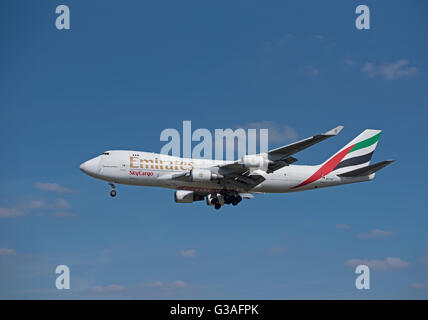 Comune di TNT Airways e Emarites SkyCargo Boeing 747-4HAERF trasportatore avvicina Londra Heathrow. SCO 10,403. Foto Stock