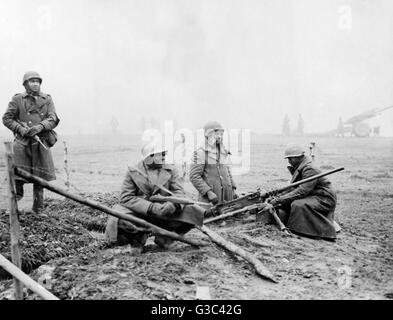 Un Americano campo unità di artiglieria scavare nel lungo una strada belga, in posizione di attesa a terra contro il tedesco della controffensiva nella zona delle Ardenne del Belgio che divenne noto come la Battaglia di Bulge. Da sinistra a destra, privato G.F.Morris di New York Foto Stock