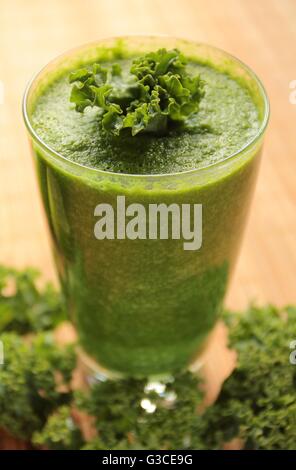 Un sano frullato verde con cavolo verde in un bicchiere Foto Stock