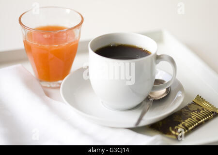 Tazza di caffè con succo di arancia sul vassoio bianco Foto Stock