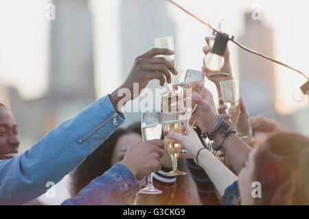 Giovani amici adulti tostatura flauti champagne a parte Foto Stock