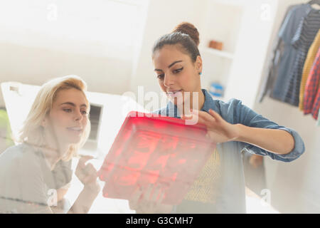 Innovativi di giovani imprenditrici esaminando prototipo Foto Stock