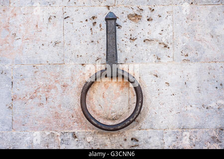 Antico anello di ferro per legare i cavalli sul muro di pietra, Siena Toscana Italia. Foto Stock