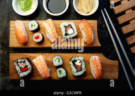 Selezione di sushi compresi i gamberetti, salmone e verdure con riso su blocchi di servizio Foto Stock