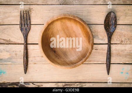 Ciotole di legno e cucchiaio con forcella sullo sfondo di legno Foto Stock