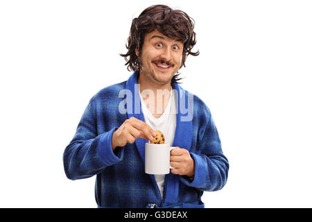 Uomo con un bicchiere di latte e di immersione a pezzetti di cioccolato in esso isolato su sfondo bianco Foto Stock