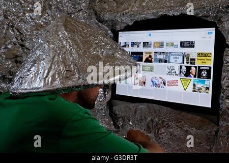 Maschio di teoria della cospirazione credente che indossa la lamina di tin hat Foto Stock